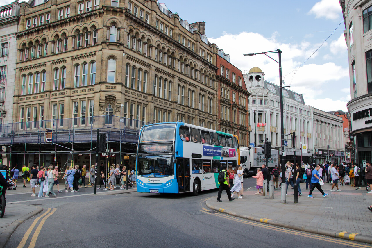 A double-decker bus travelling through Manchester City Centre